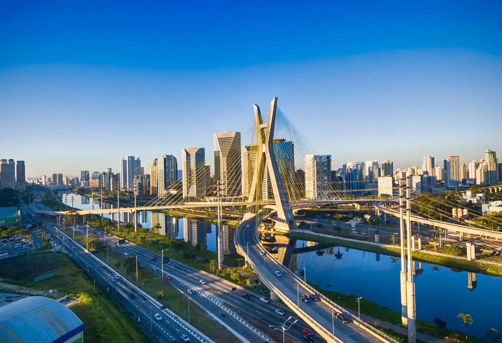 Vista moderna de São Paulo con el icónico puente Octavio Frias de Oliveira sobre el río Pinheiros en día soleado.