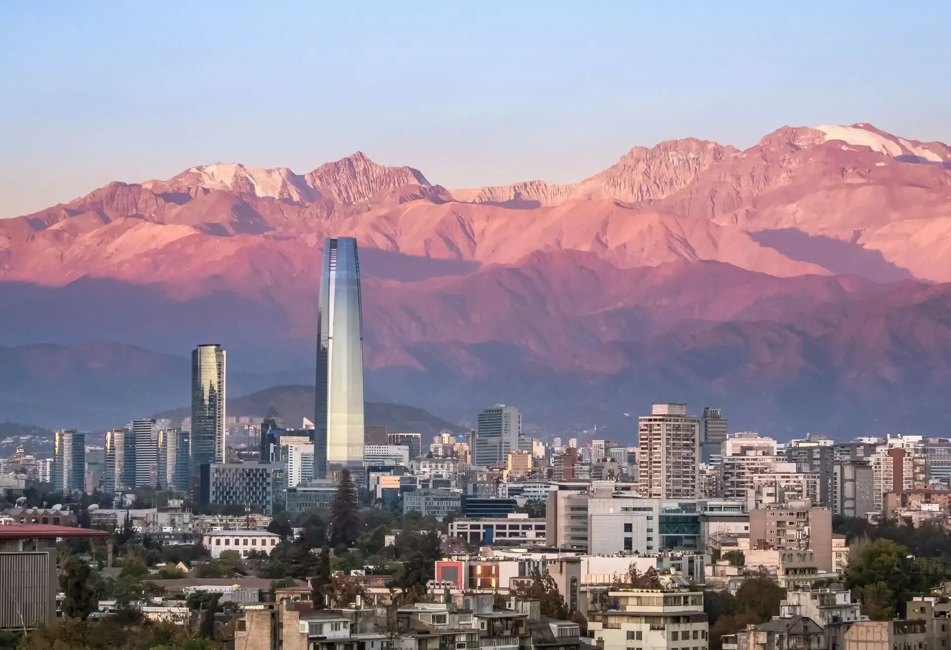 Vista urbana de Santiago con la Cordillera de los Andes y edificios modernos, vuelos desde 530 USD con LATAM.