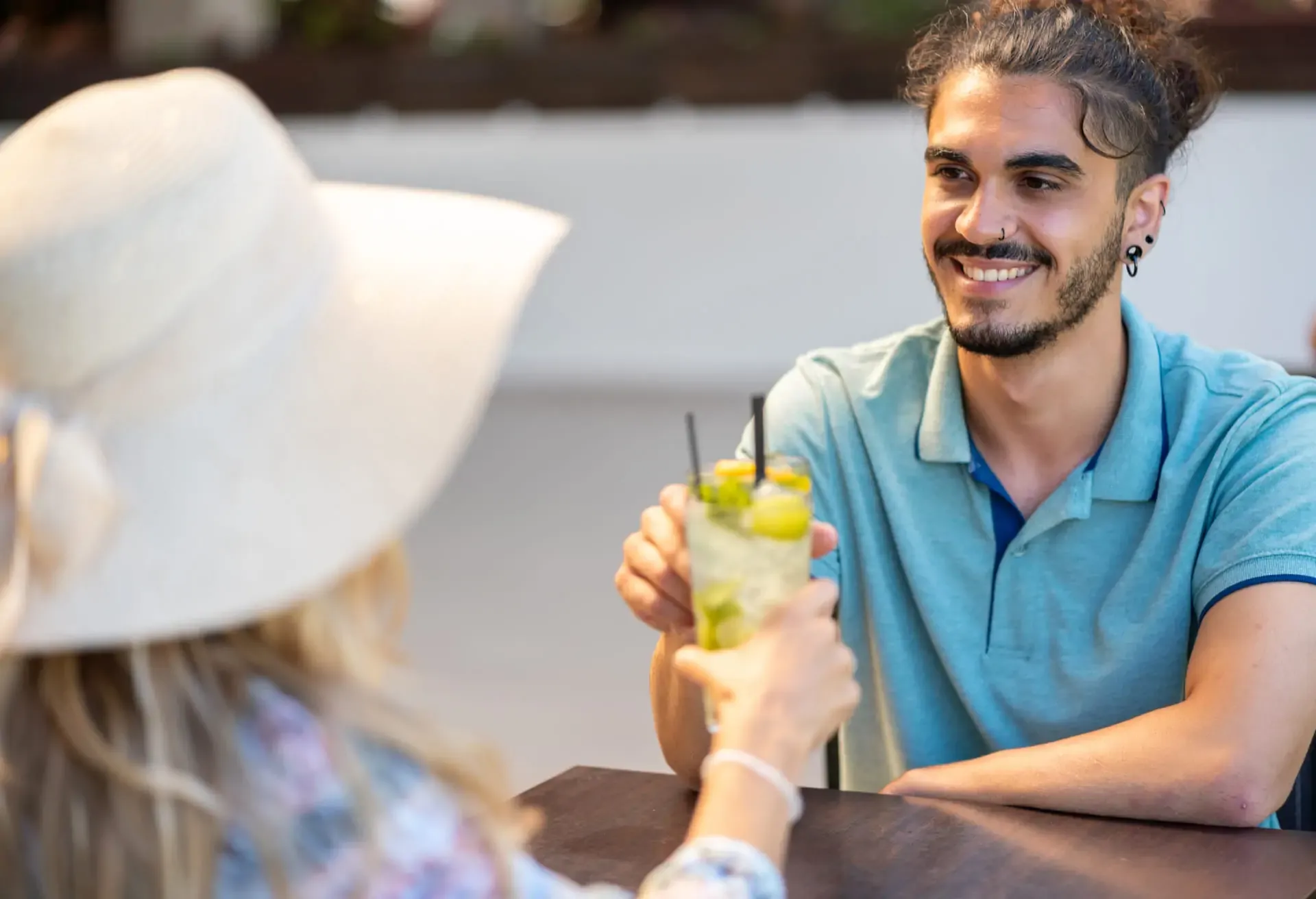 Personas conversando y brindando con bebidas frescas en una terraza luminosa, perfecta para disfrutar un St-Germain Spritz.